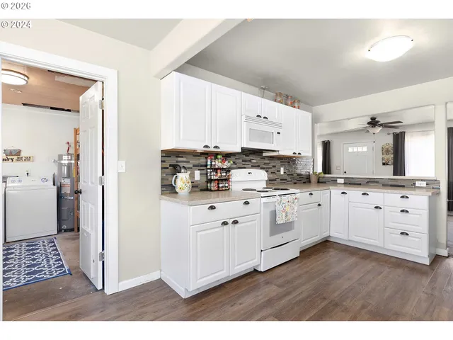 a kitchen with cabinets a sink and white appliances
