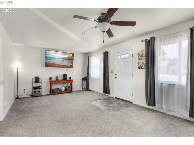 a view of kitchen with refrigerator and white cabinets