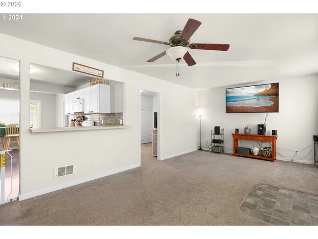 a view of a livingroom with furniture and a kitchen view