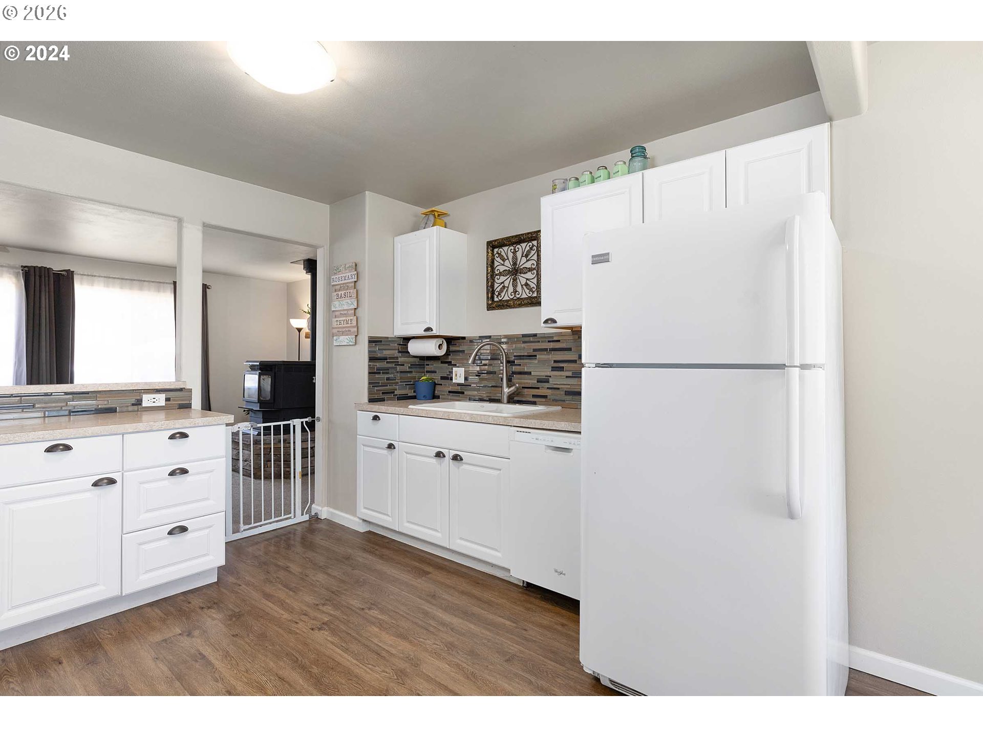 1669 Hayes Street North Bend, OR 97459 - Photo 30 of 30 a kitchen with white cabinets and refrigerator