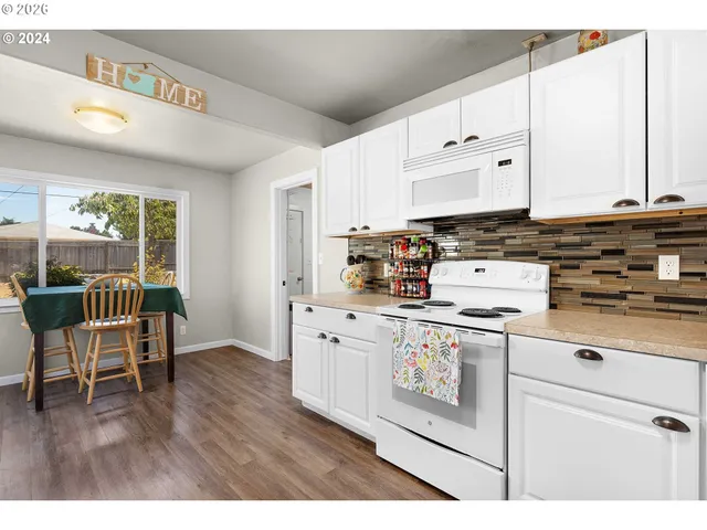 a kitchen with appliances cabinets and wooden floor