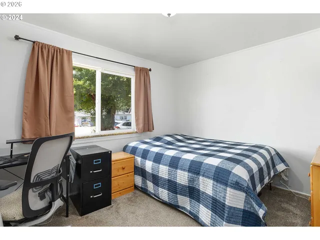 a bedroom with a bed and a window