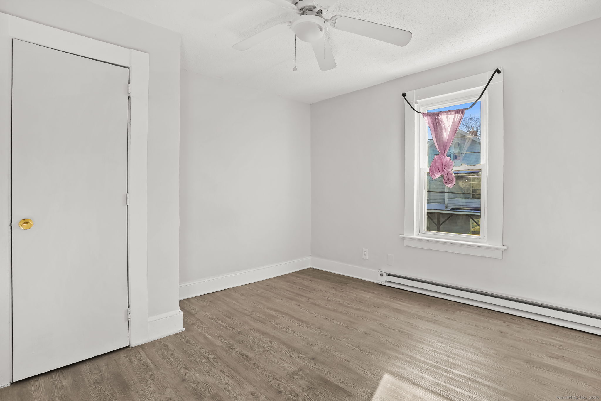 7 George Street, Unit 2 Torrington, CT 06790 - Photo 5 of 11 a view of an empty room with a window and a ceiling fan