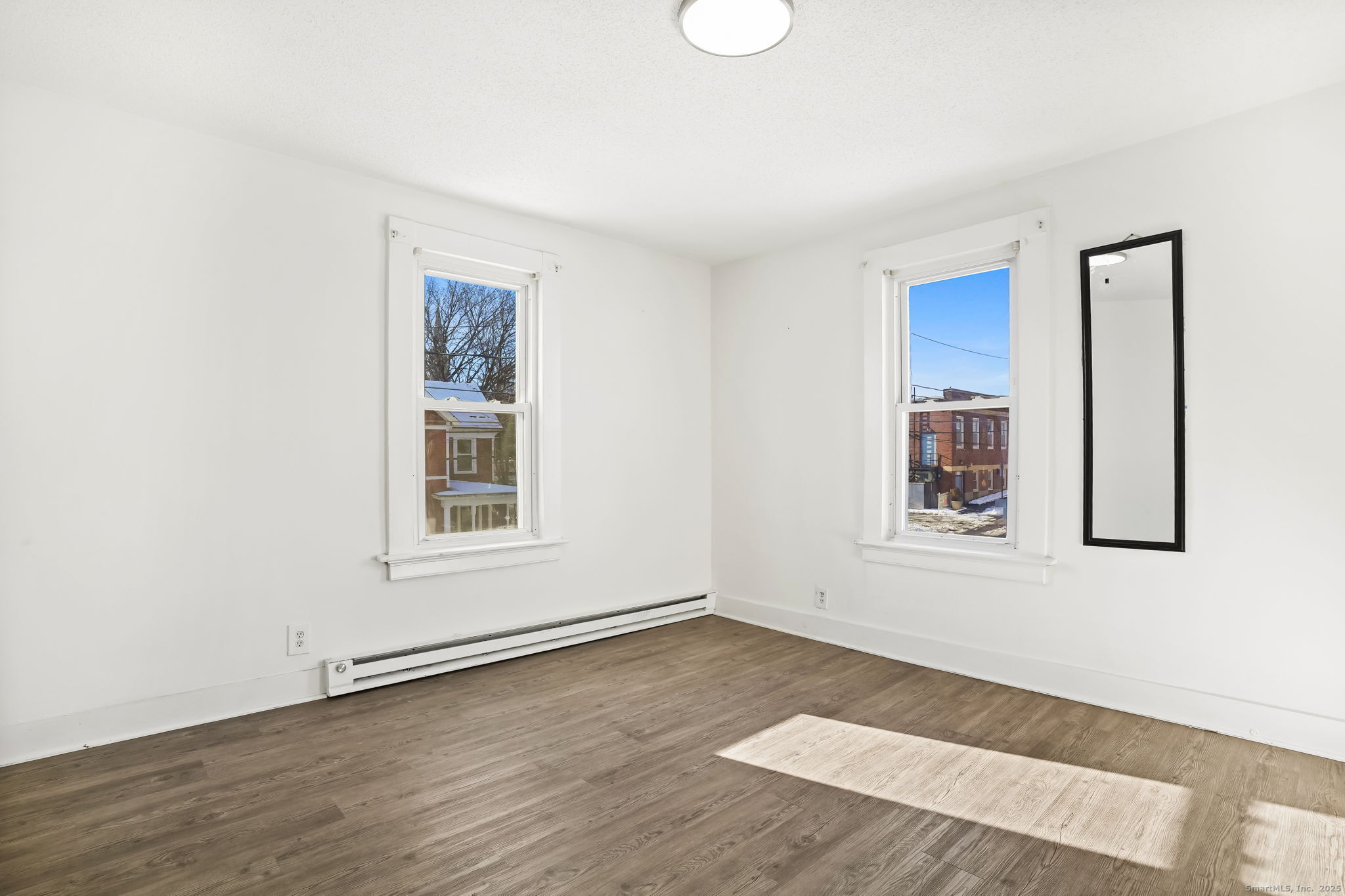 7 George Street, Unit 2 Torrington, CT 06790 - Photo 6 of 11 a view of an empty room with wooden floor and a window