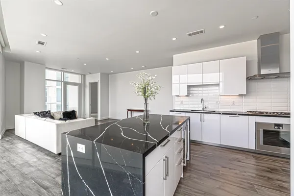a kitchen with granite countertop a sink a counter top space and stainless steel appliances