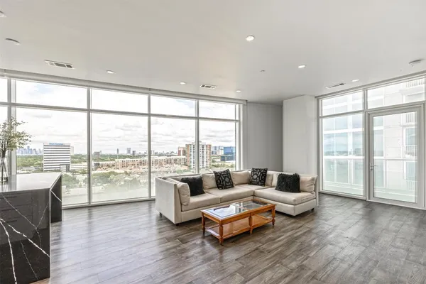 a living room with furniture and floor to ceiling windows