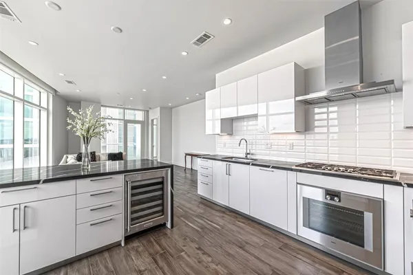 a kitchen with granite countertop cabinets stainless steel appliances a sink and window