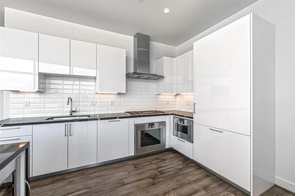 a kitchen with stainless steel appliances granite countertop a stove a sink and a refrigerator