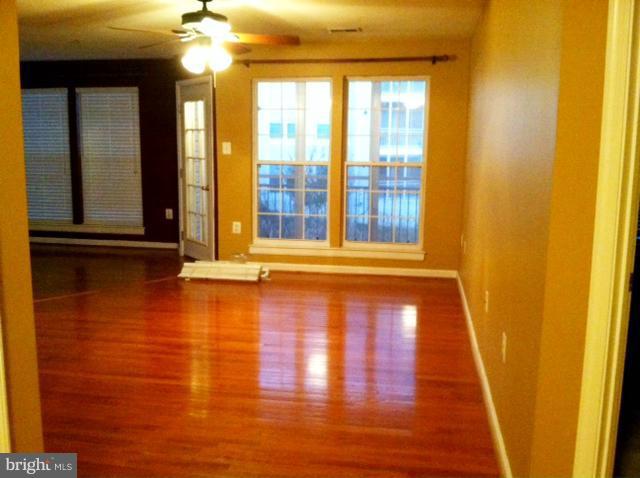 12008 Amber Ridge Circle, Unit A201 Germantown, MD 20876 - Photo 3 of 17 a view of a room with wooden floor and door