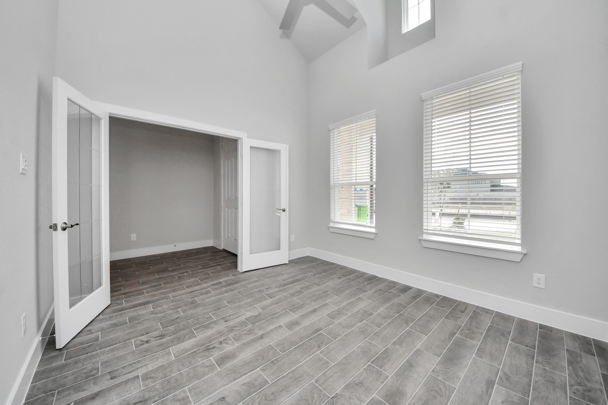 3023 Native Spg Drive Spring, TX 77373 - Photo 7 of 50 Experience the perfect blend of sophistication and warmth in this home office, boasting elegant wood-look tile flooring and flooded with natural light from expansive windows and French doors.
