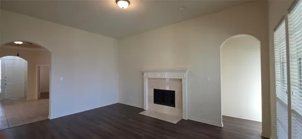 a view of a hallway with wooden floor and a chandelier