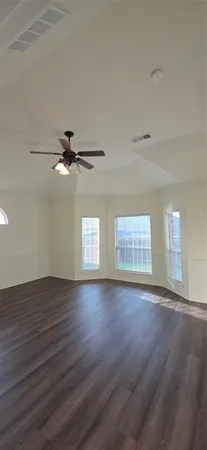 a view of an empty room with wooden floor