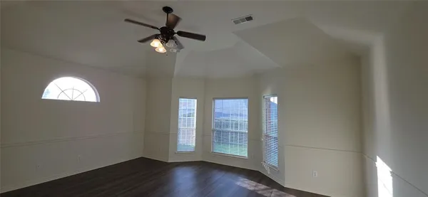 a view of empty room with wooden floor