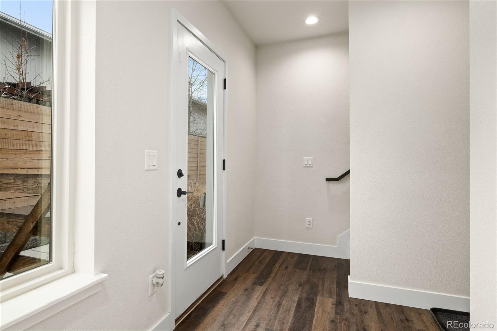 1204 South Reed Street Lakewood, CO 80232 - Photo 29 of 45 a view of a hallway with wooden floor and a bathroom