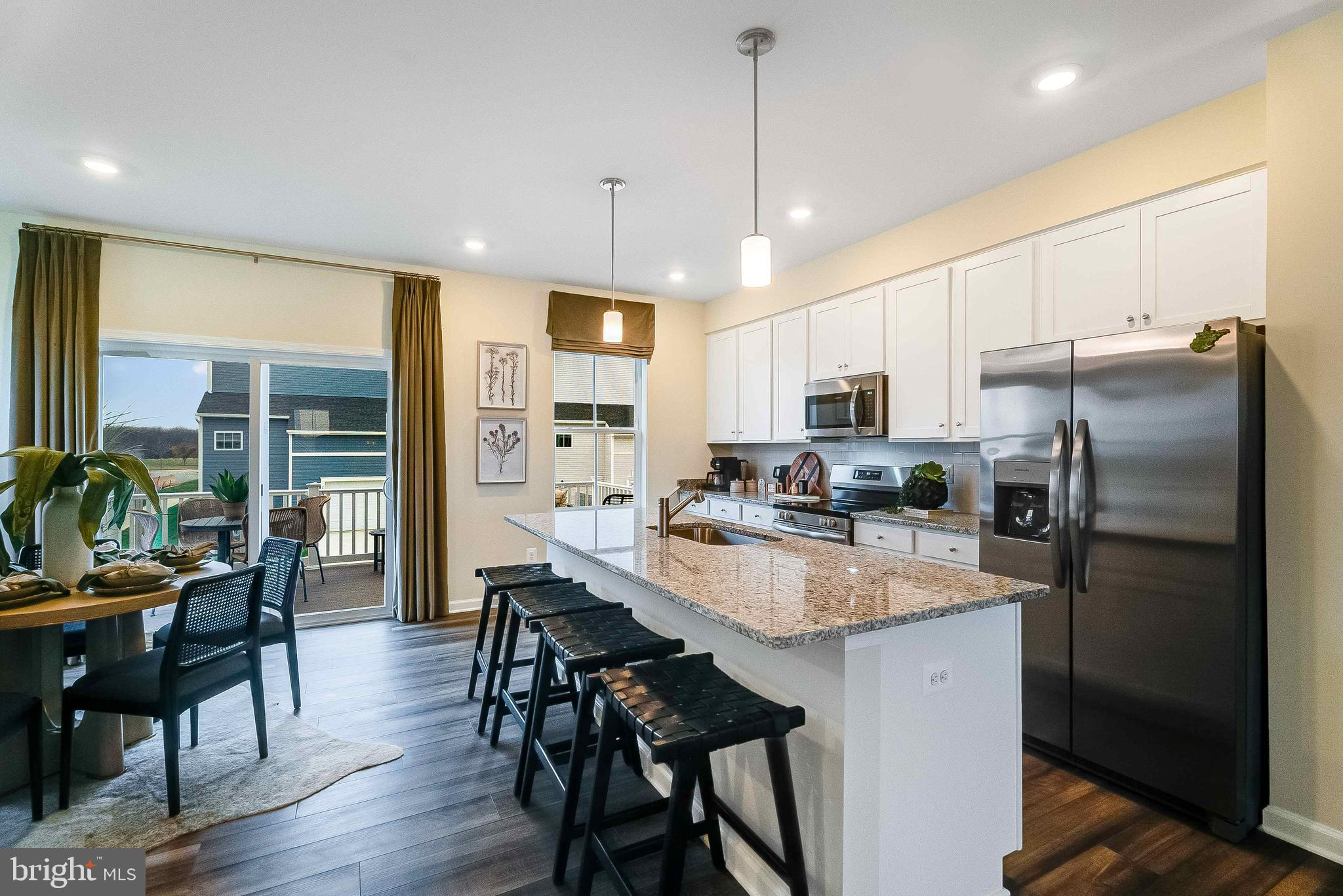 1252 Red Clover Lane Ranson, WV 25438 - Photo 8 of 24 a kitchen with stainless steel appliances granite countertop a refrigerator a stove a sink a dining table and chairs with wooden floor