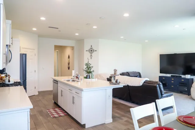 a large white kitchen with a large window and stainless steel appliances