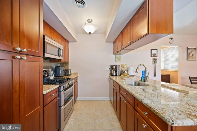 a kitchen with stainless steel appliances granite countertop a sink stove and refrigerator