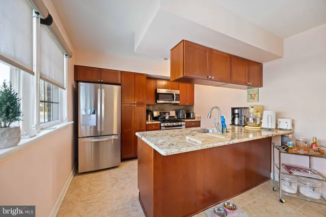 a kitchen with stainless steel appliances granite countertop a refrigerator a sink and a stove