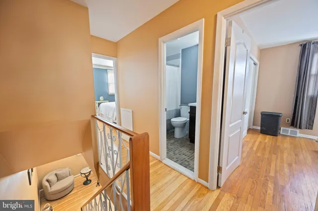 a view of a hallway with wooden floor and staircase