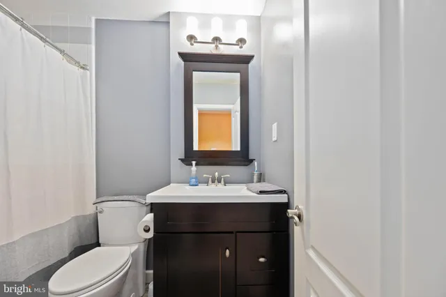 a bathroom with a sink vanity mirror and toilet