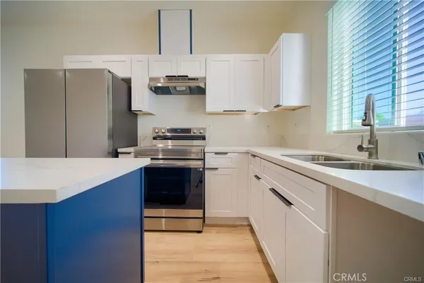 a kitchen with stainless steel appliances a sink stove and refrigerator