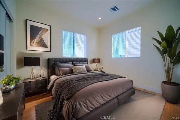 a bedroom with bed and a potted plant