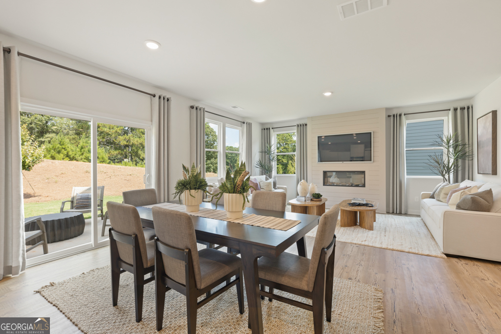 5412 Aurora Trail Flowery Branch, GA 30542 - Photo 14 of 36 a view of a dining room with furniture large windows and wooden floor