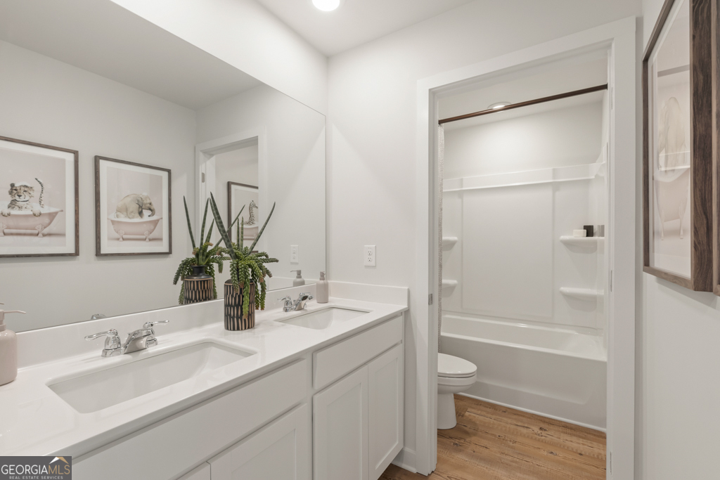 5412 Aurora Trail Flowery Branch, GA 30542 - Photo 26 of 36 a bathroom with a granite countertop sink a toilet and shower
