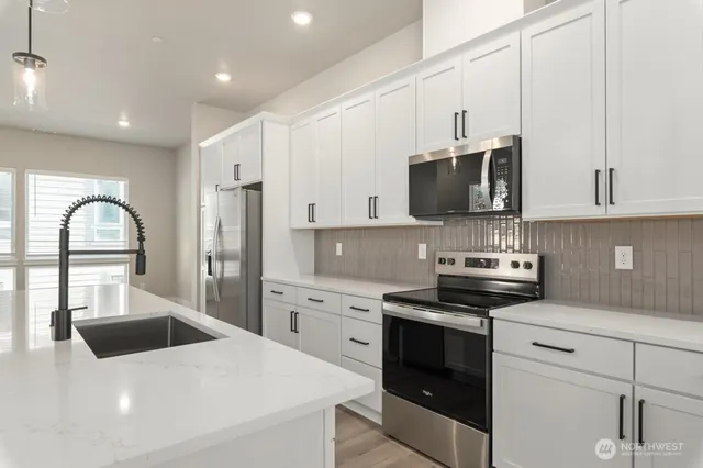 a kitchen with stainless steel appliances kitchen island granite countertop a stove a sink and a microwave