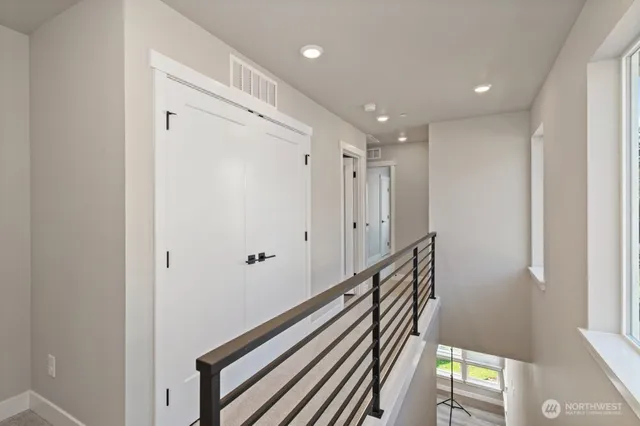 a view of a hallway with wooden floor and staircase