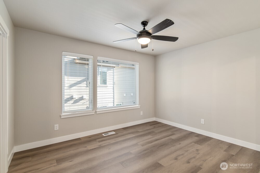 12814 66th Avenue South Seattle, WA 98178 - Photo 21 of 28 an empty room with wooden floor fan and windows