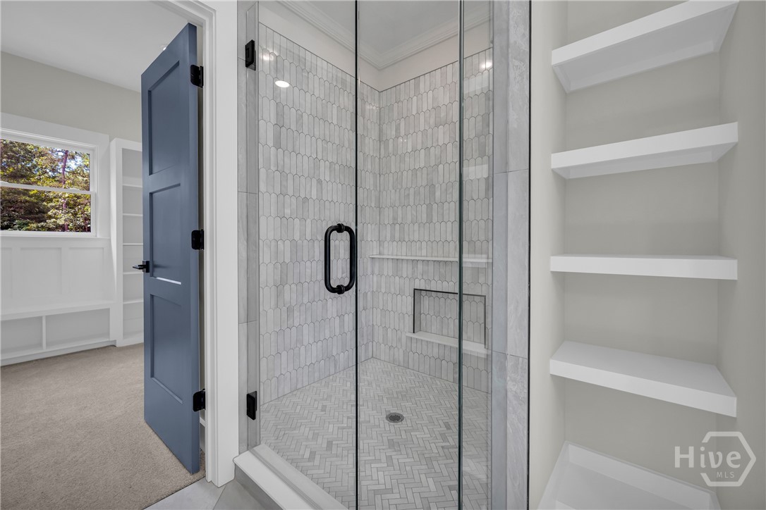 2476 St Martin Way Monroe, GA 30656 - Photo 44 of 75 Glass-enclosed shower featuring picketed tile walls, a built-in shower niche, and matte black hardware