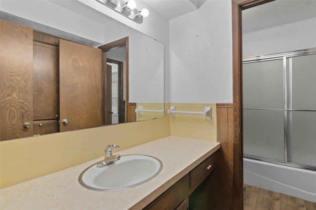 301 East 6th Street Krum, TX 76249 - Photo 22 of 29 Bathroom with large vanity, beautiful custom cabinetry and a shower/tub combination.