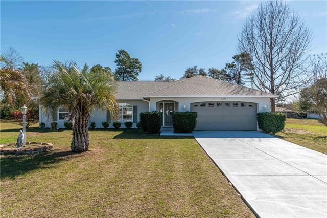 a front view of house with yard and trees in the background