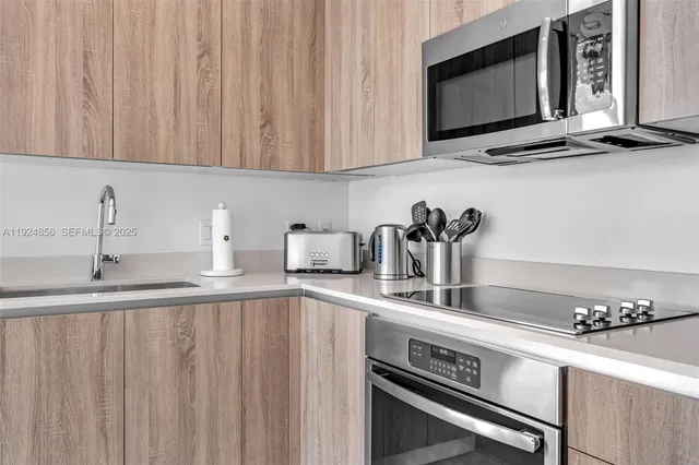 a kitchen with stainless steel appliances a sink stove and cabinets