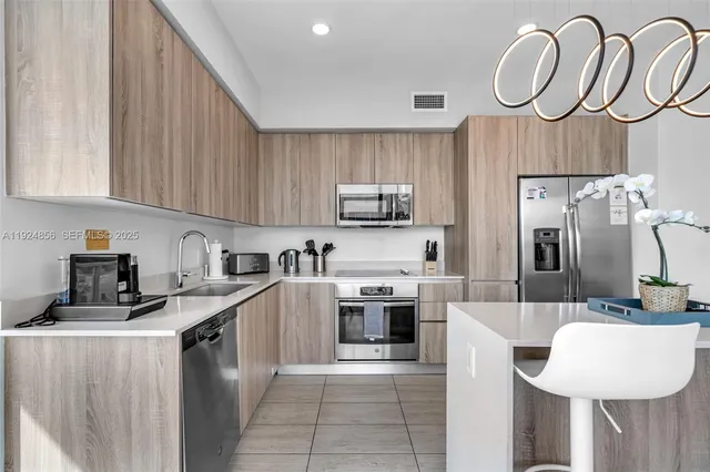 a kitchen with kitchen island granite countertop a sink stainless steel appliances and white cabinets