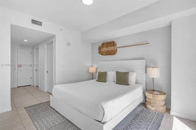 a bedroom with a bed and a mirror on dresser