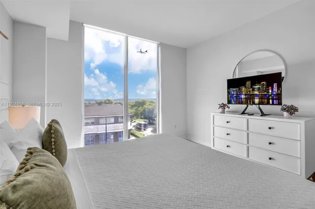 a large white bed sitting in a bedroom and table