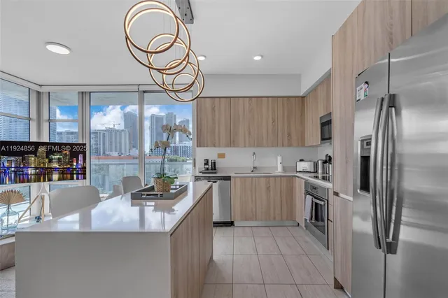 a kitchen with stainless steel appliances granite countertop a sink and a refrigerator