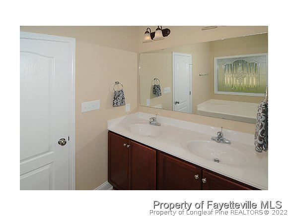 52 Regimental Drive Cameron, NC 28326 - Photo 7 of 12 a bathroom with a sink vanity and mirror