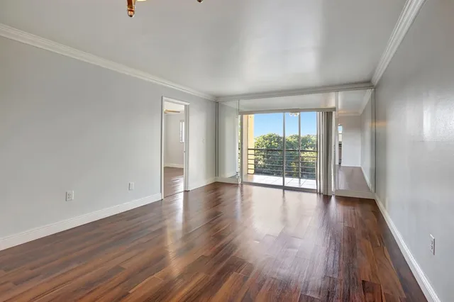 a view of empty room with wooden floor