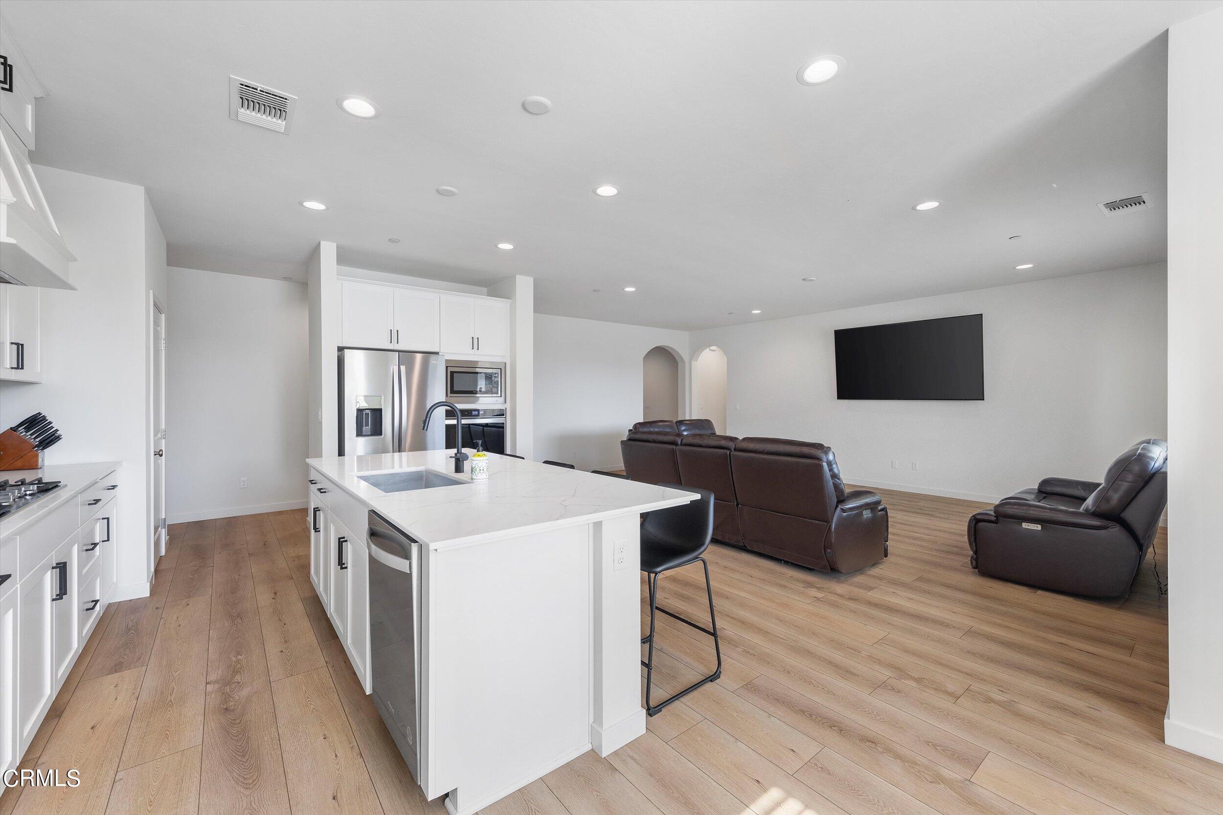 7405 Emerald Green Avenue Bakersfield, CA 93313 - Photo 11 of 39 a living room with stainless steel appliances furniture and a flat screen tv