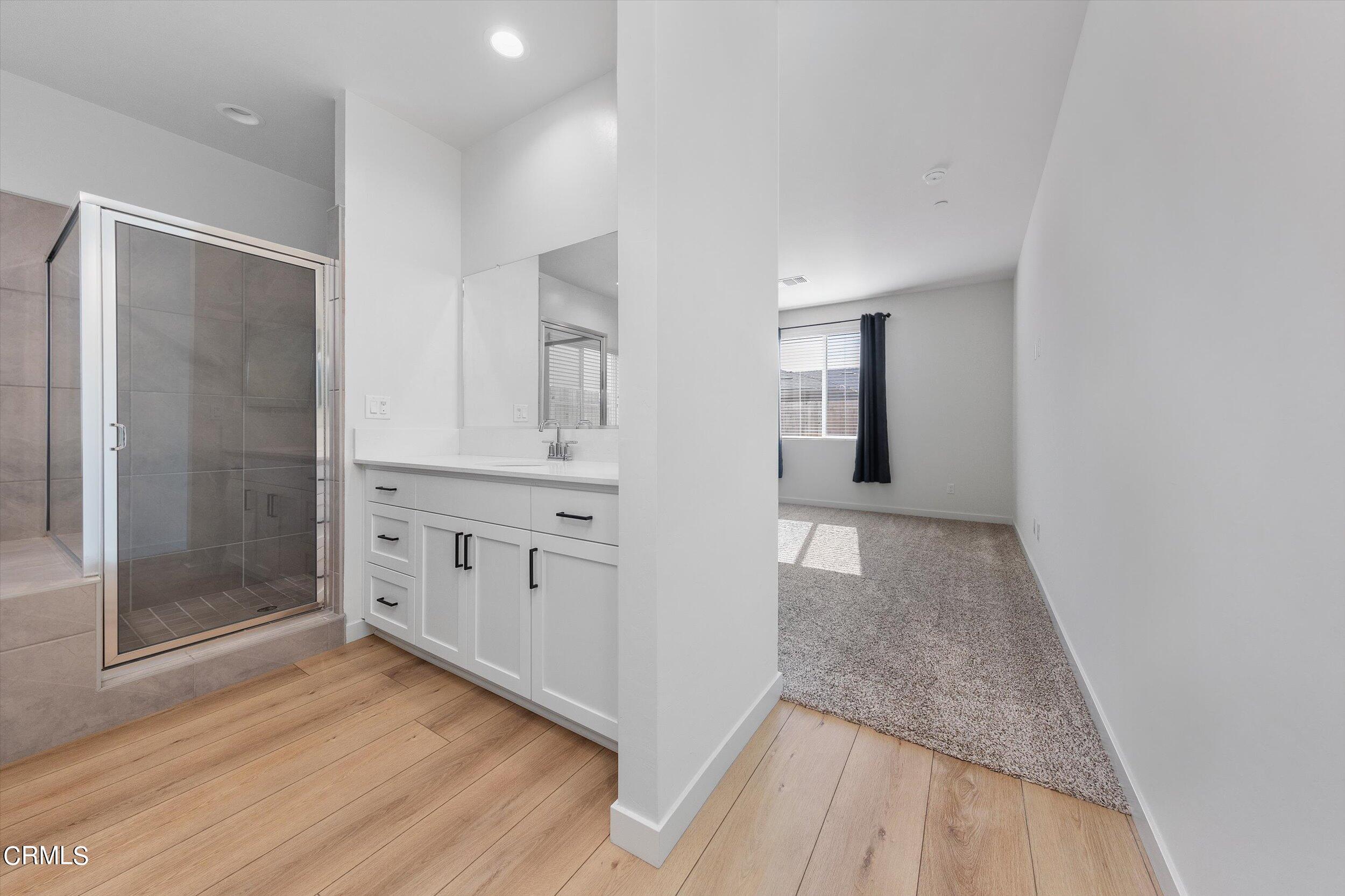 7405 Emerald Green Avenue Bakersfield, CA 93313 - Photo 19 of 39 a view of a hallway with wooden floor and cabinet