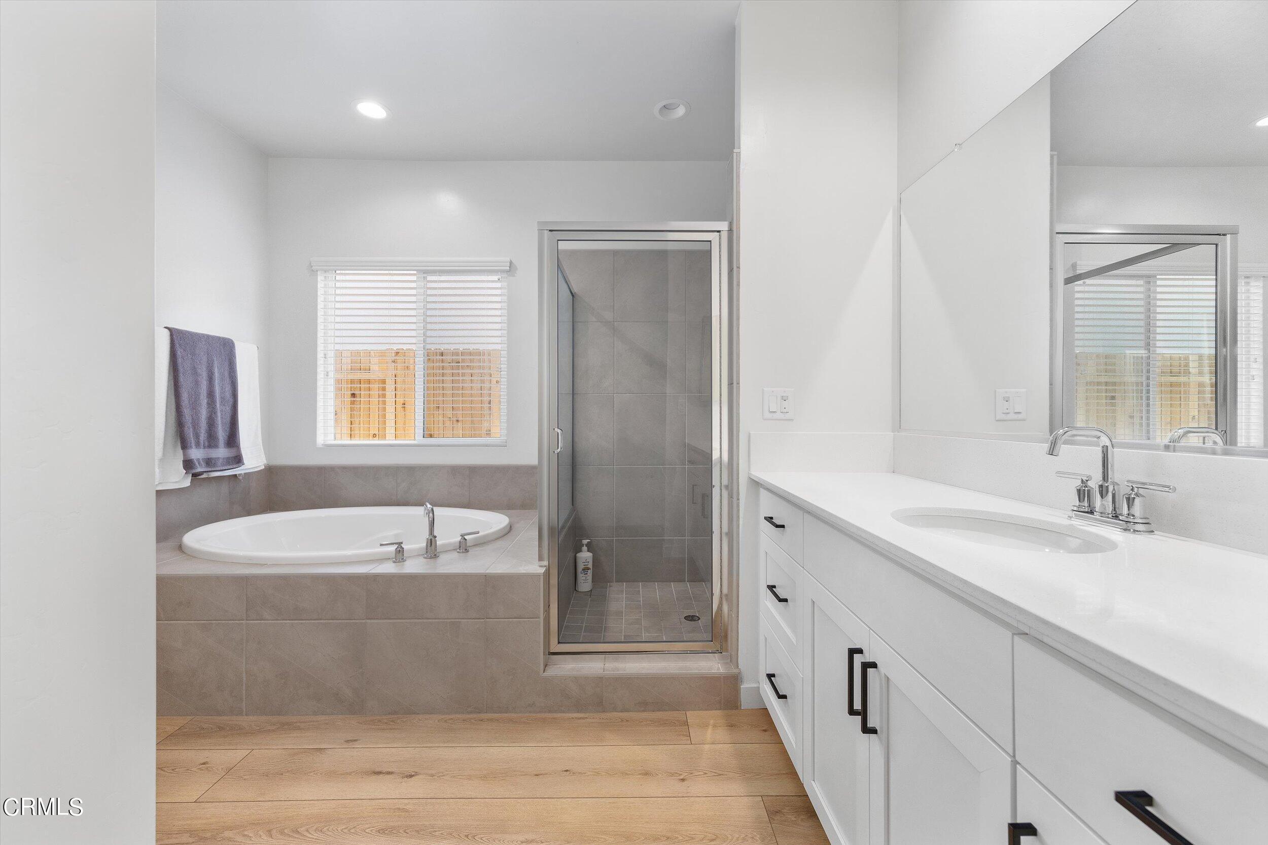 7405 Emerald Green Avenue Bakersfield, CA 93313 - Photo 22 of 39 a spacious bathroom with a bathtub sink and mirror