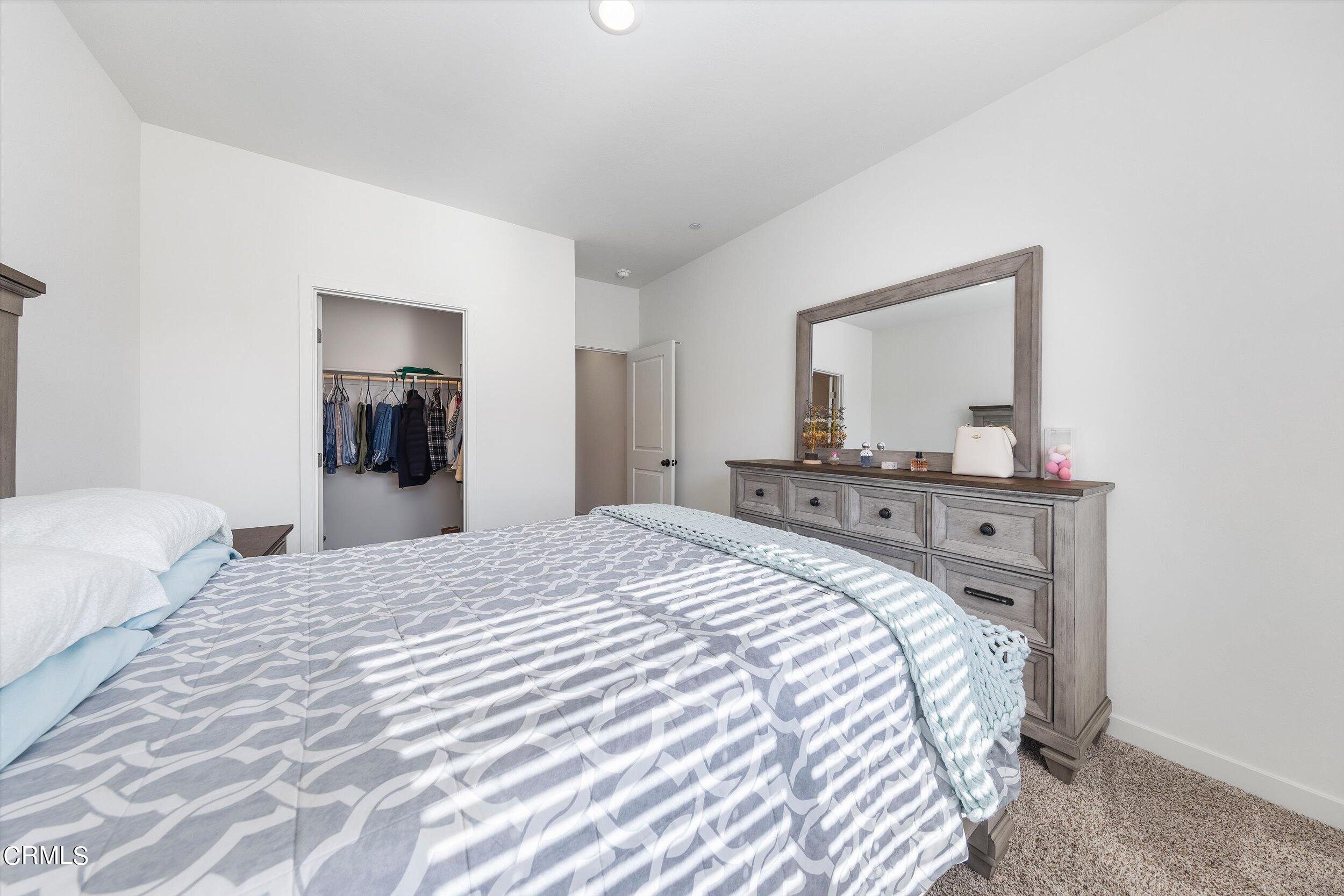 7405 Emerald Green Avenue Bakersfield, CA 93313 - Photo 26 of 39 a bedroom with a bed and a mirror