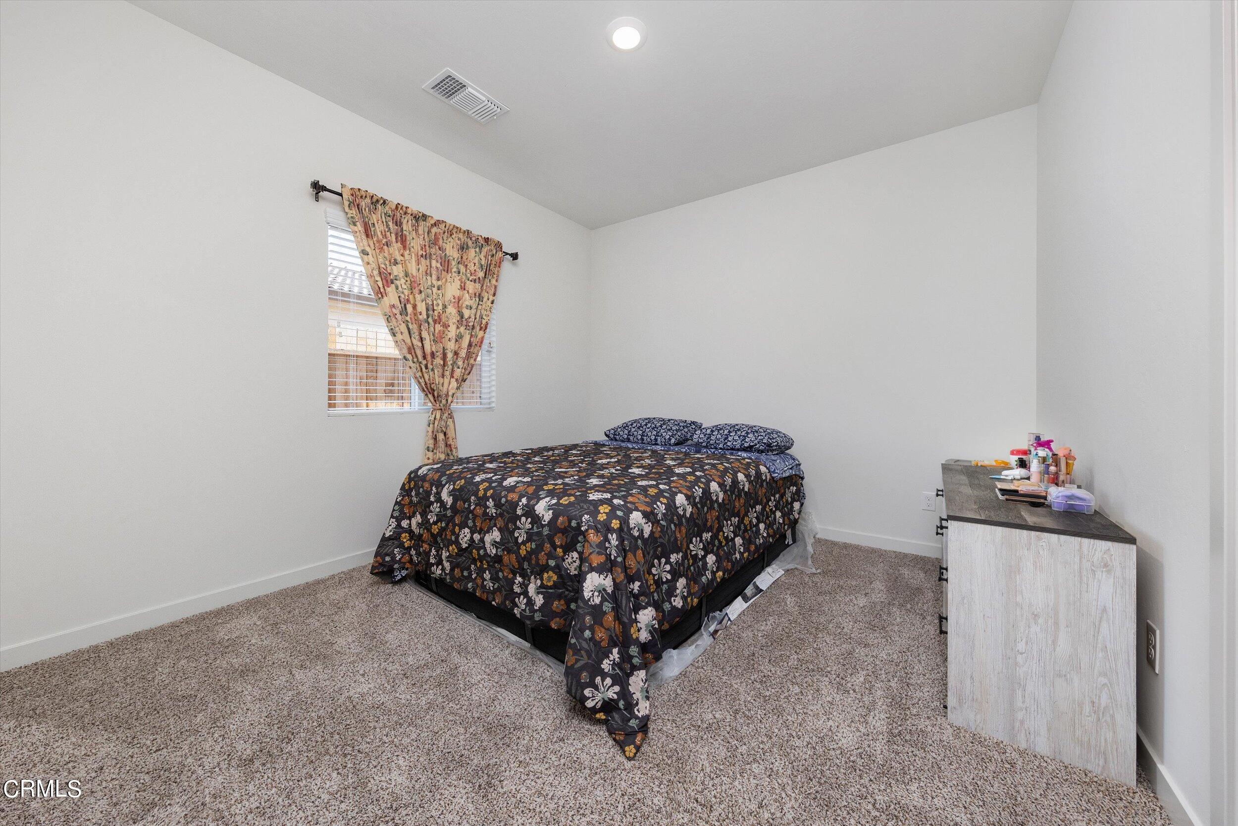 7405 Emerald Green Avenue Bakersfield, CA 93313 - Photo 29 of 39 a bedroom with a bed and a window