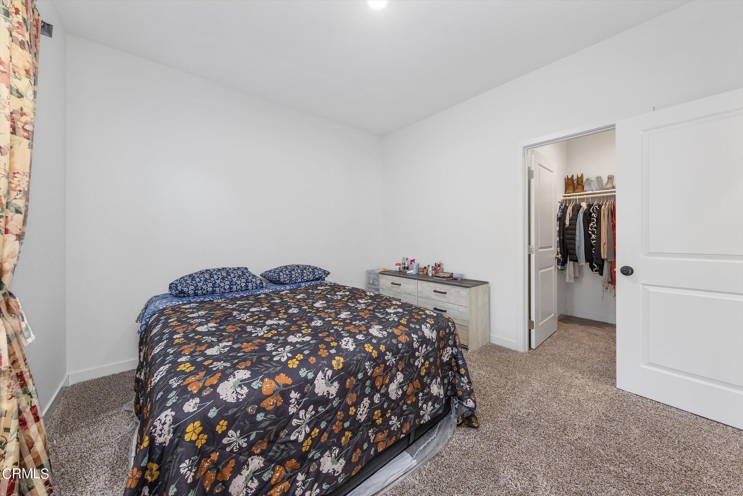7405 Emerald Green Avenue Bakersfield, CA 93313 - Photo 30 of 39 a bedroom with a bed and a lamp