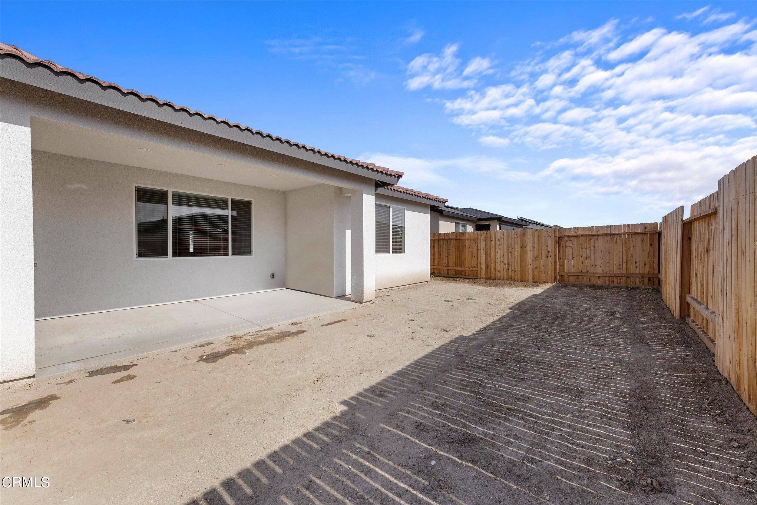 7405 Emerald Green Avenue Bakersfield, CA 93313 - Photo 38 of 39 a house with wooden doors and outdoor space