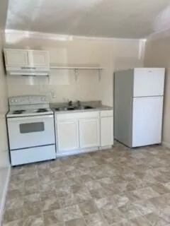 a kitchen with white cabinets and a refrigerator