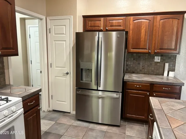 a kitchen with stainless steel appliances granite countertop a refrigerator and a stove